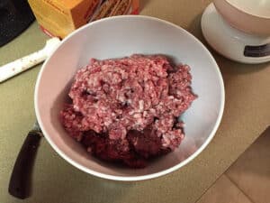 venison and pork mixed in a bowl to make hot dogs